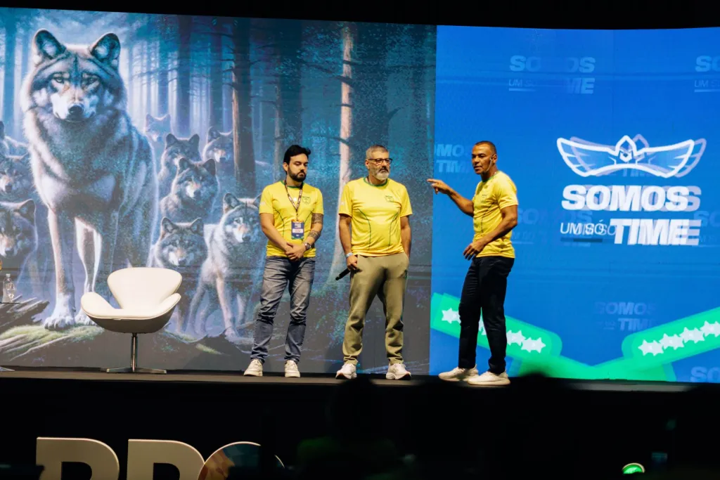 Convidados no palco com o painel dos lobos