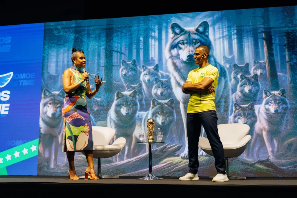 Palestrante e Cafu no palco com o painel Somos um só time